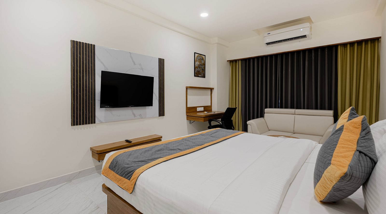 Contemporary room with bed, lounge chair, and blackout curtains at Lemonridge Hotels, IDPL Balanagar.