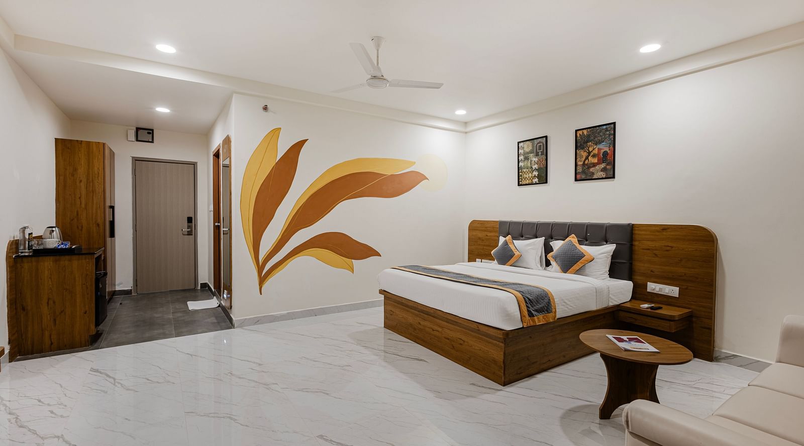 Bright premium room with painted wall mural, comfortable bed, and stylish furniture at Lemonridge Hotels, IDPL Balanagar.