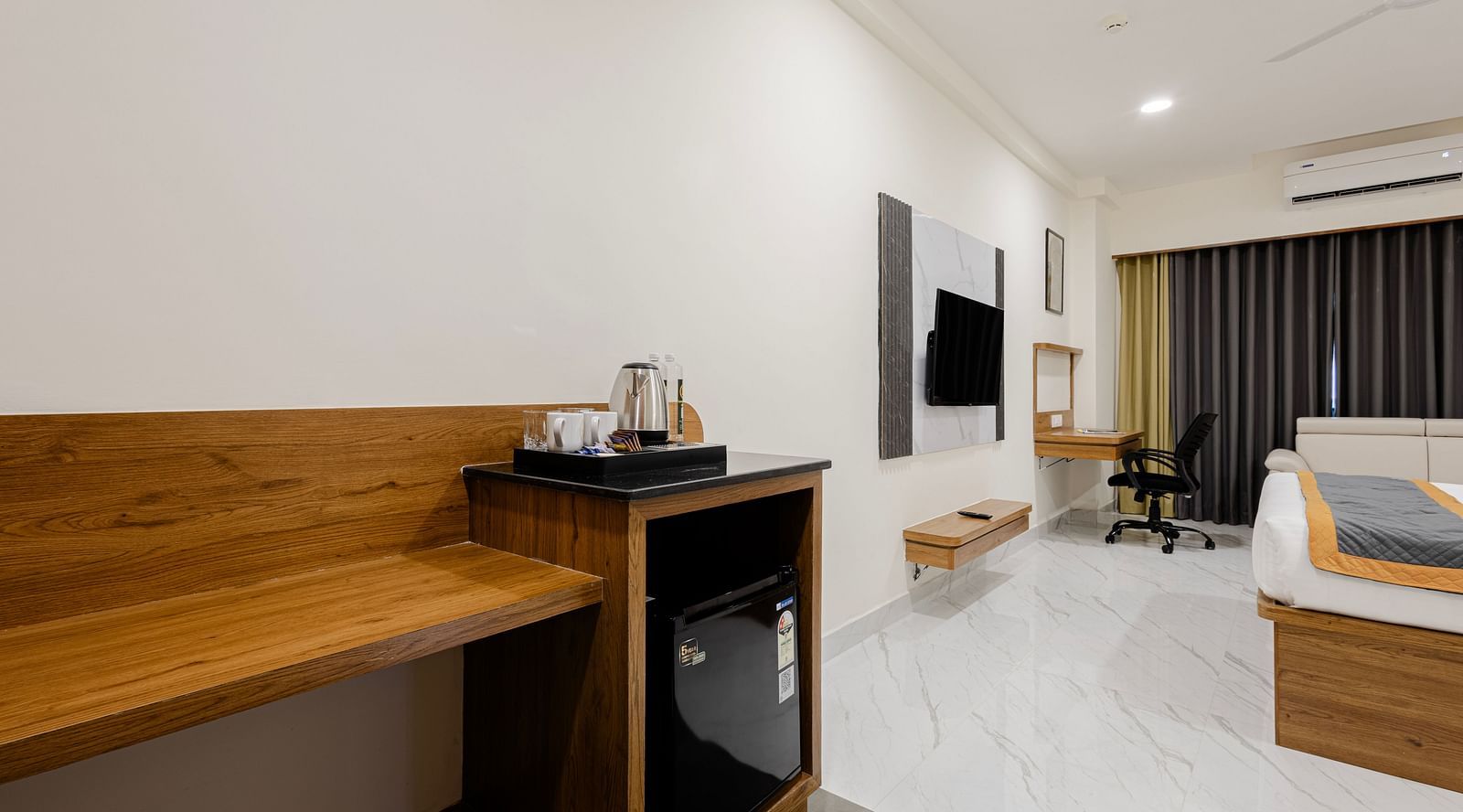 Refreshment and workspace area in a premium room featuring a kettle and bottled water at Lemonridge Hotels, IDPL Balanagar.