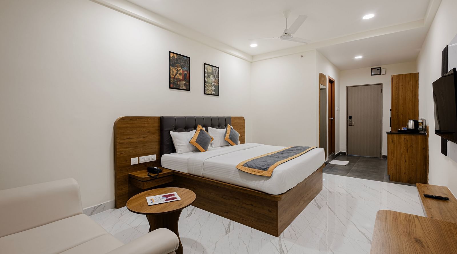 Spacious room with wooden furniture and minimalist décor at Lemonridge Hotels, IDPL Balanagar.