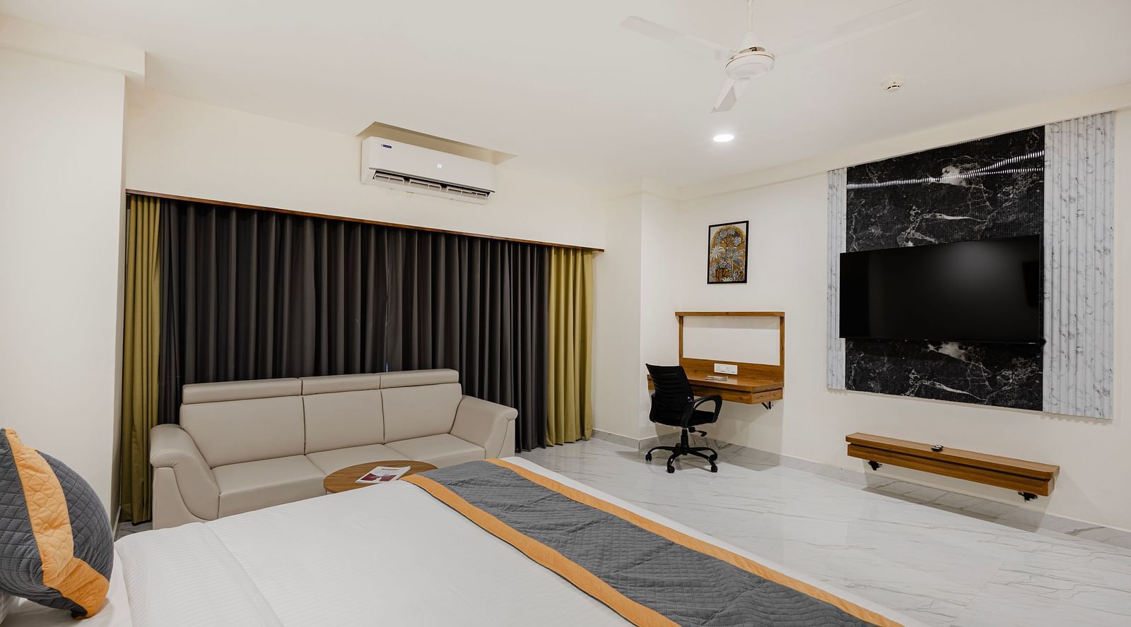 Interior view of bedroom featuring work desk and window curtains at Lemonridge Hotels, IDPL Balanagar.