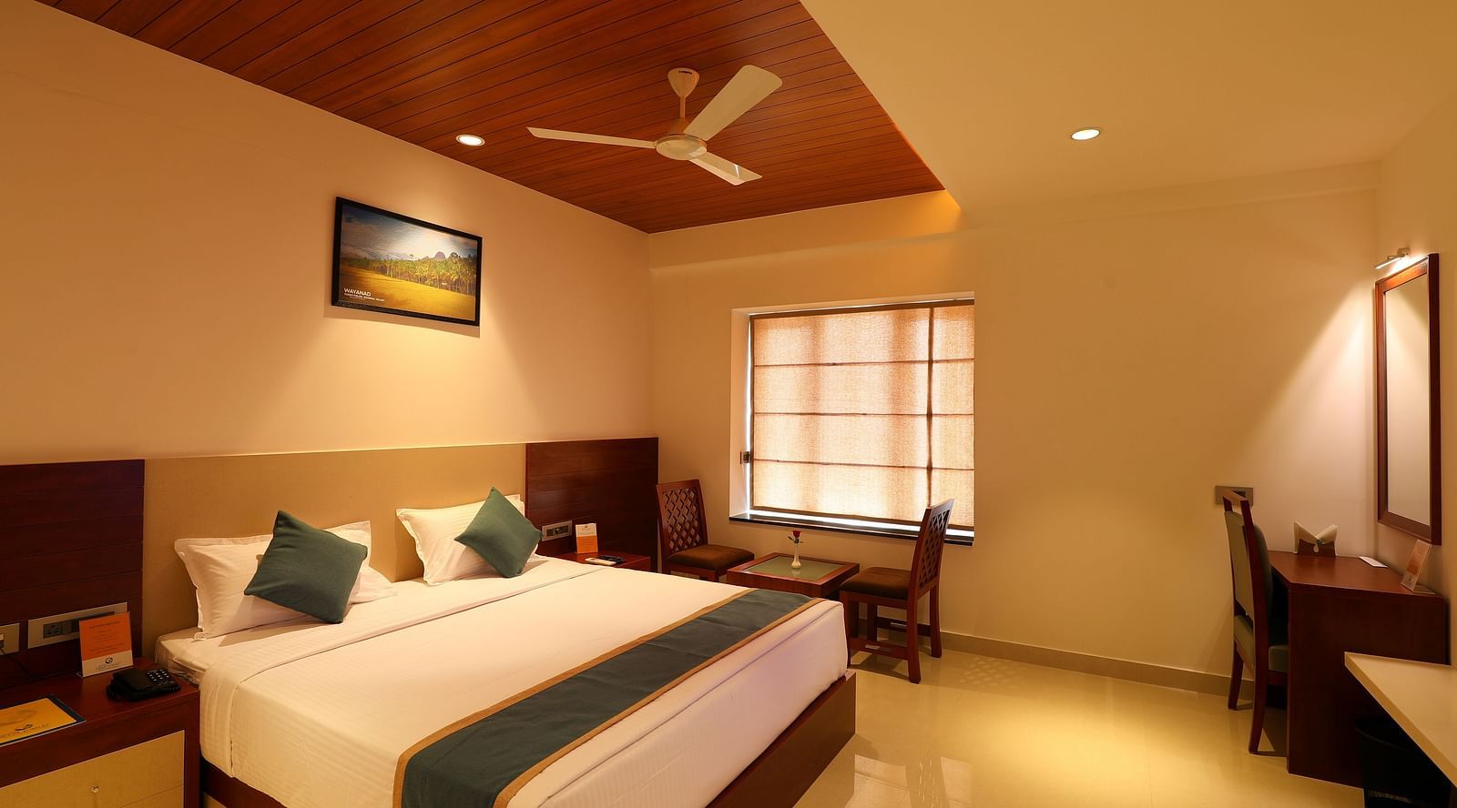 a plush bed with a picture hanging above it at Mesta Hotel