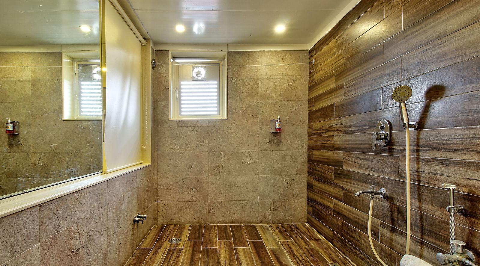 Walk-in shower with wooden and beige tiles, overhead and hand-held showerheads, and a frosted window.