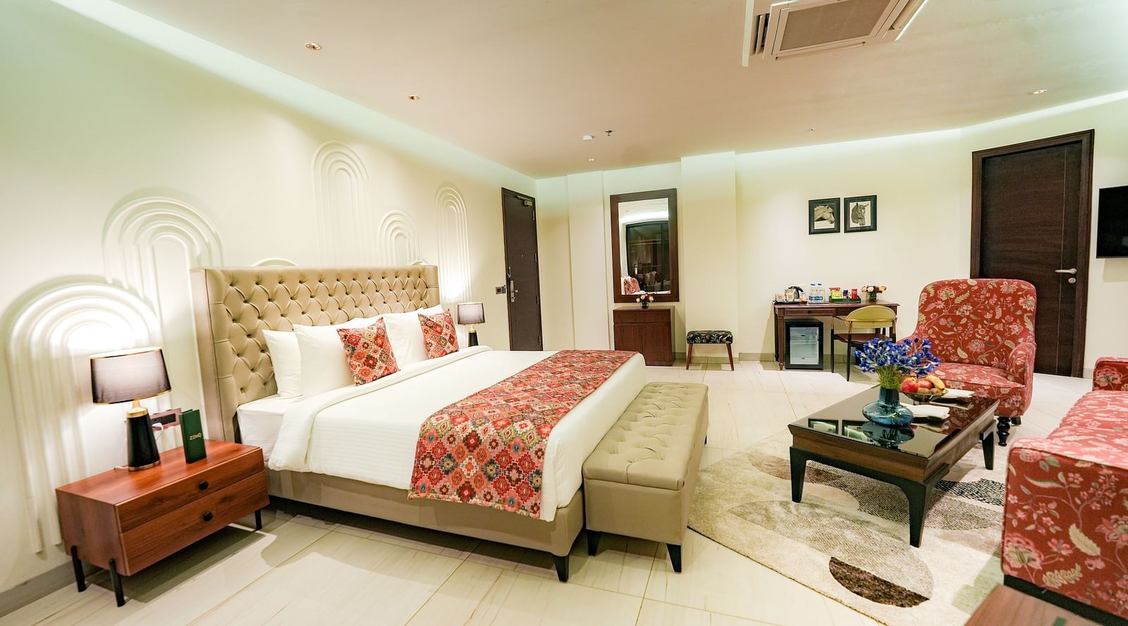 A large suite in Bankhandi featuring a queen size bed with a bed bench, a night stand with a lamp, and cosy furniture - NAMAMI BY ZENQ BANKHANDI