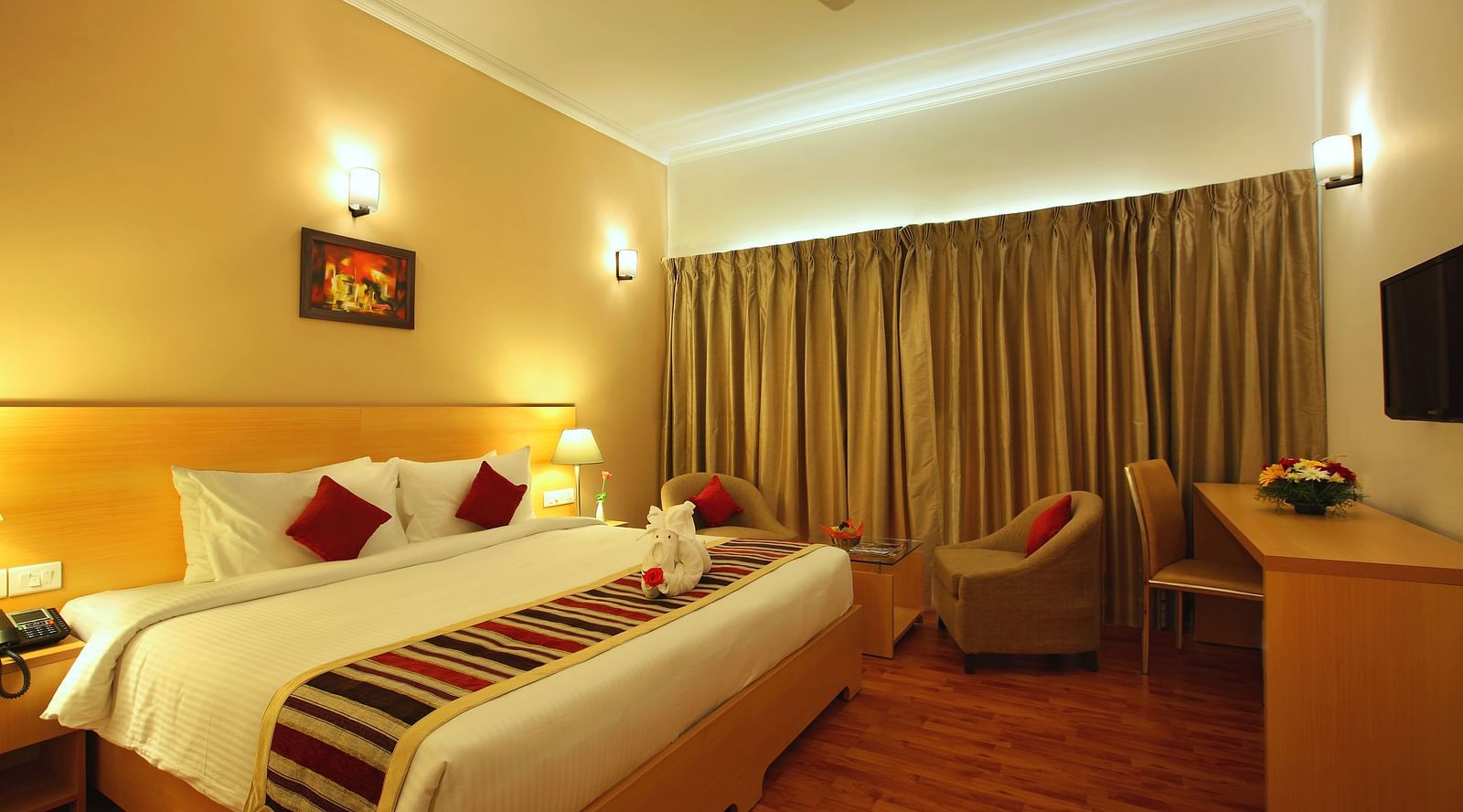A king bed with side tables and lamps inside Premium Room - Starlit Suites, Kochi
