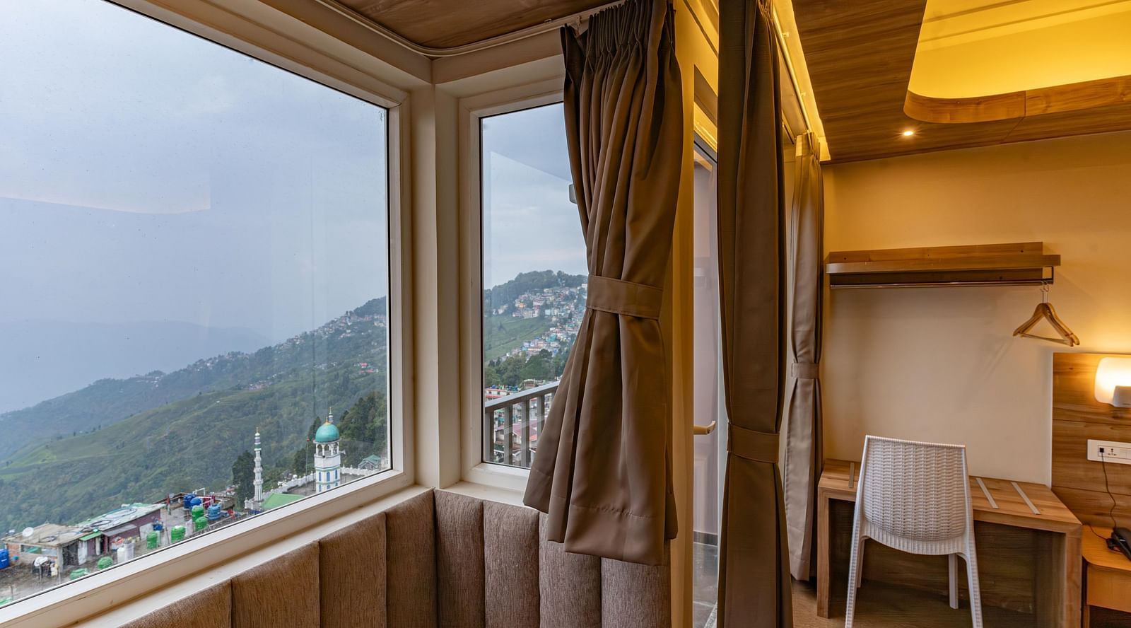 image of the premium room with a huge window exposing serene mountain views at The Soma Hotel by Avianna Group, Darjeeling