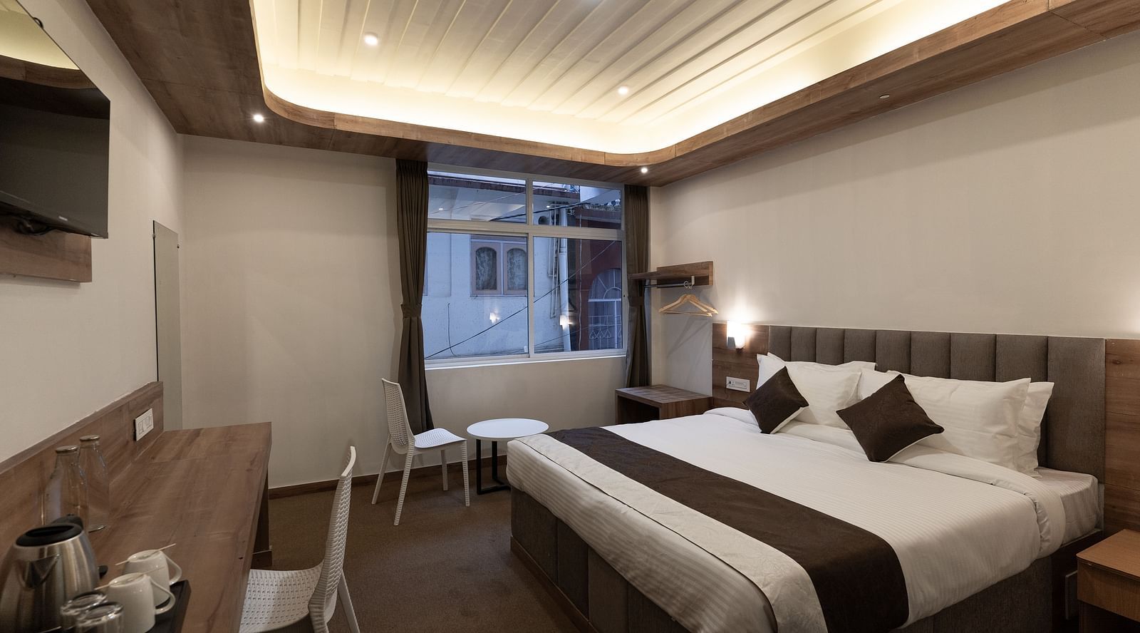 image of the Standard room with a king size bed and a window in the corner at The Soma Hotel by Avianna Group, Darjeeling