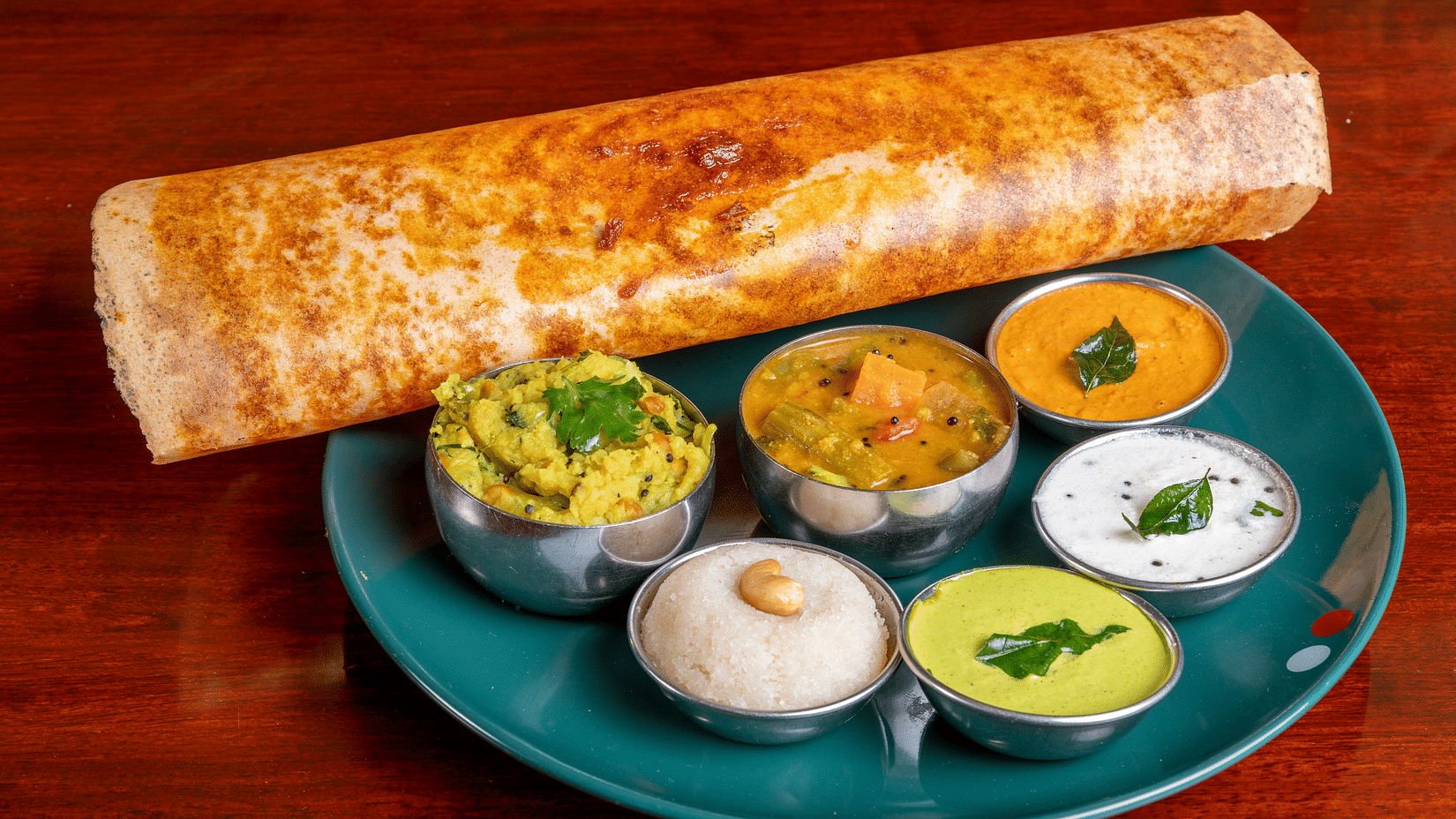 A Dosa platter with many side items kept on a plate