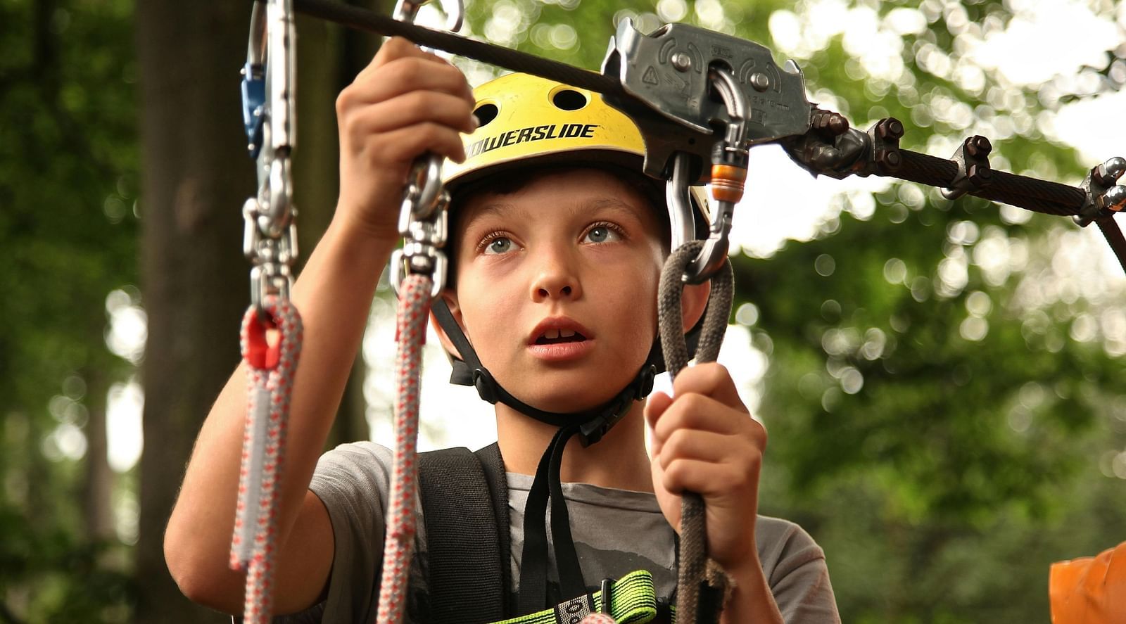 A close-up of a child with wide eyes, looking intently at a colorful string hook, showcasing their curiosity and fascination.