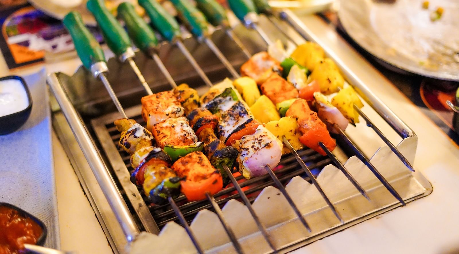 An image of a skewer stuffed with vegetables and meat in a barbecue grill at Themis Barbecue House, NSP Pitampura