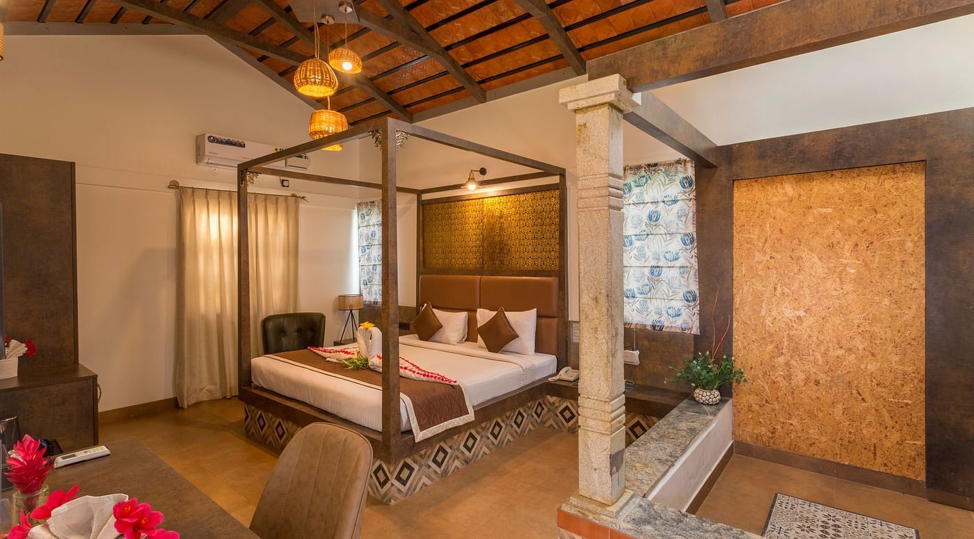Spacious room with canopy bed and warm lighting at Nirantara Resort & Spa