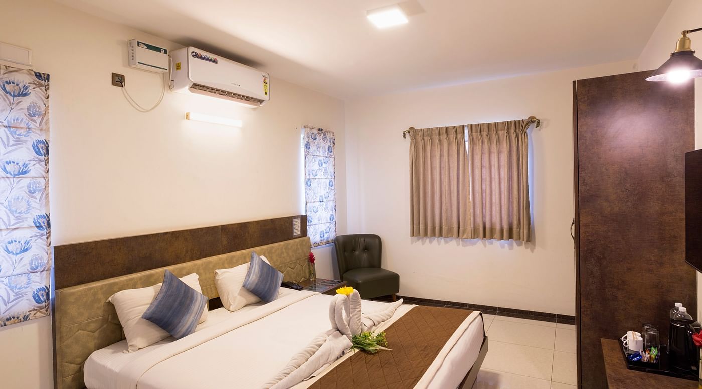 Contemporary bedroom with seating area and air conditioning – Nirantara Resort & Spa