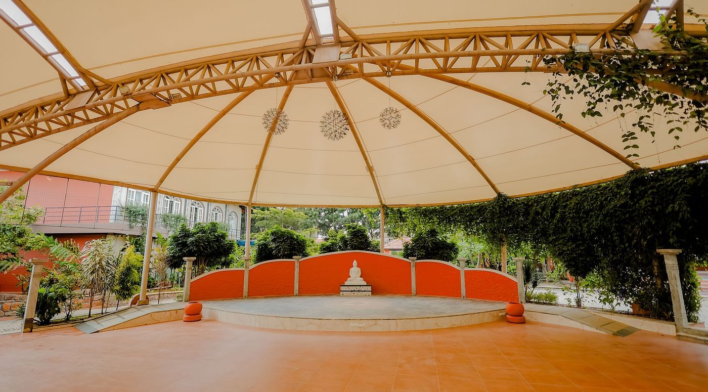 An outdoor event space with a large canopy and a stage at Nirantara Resort & Spa.