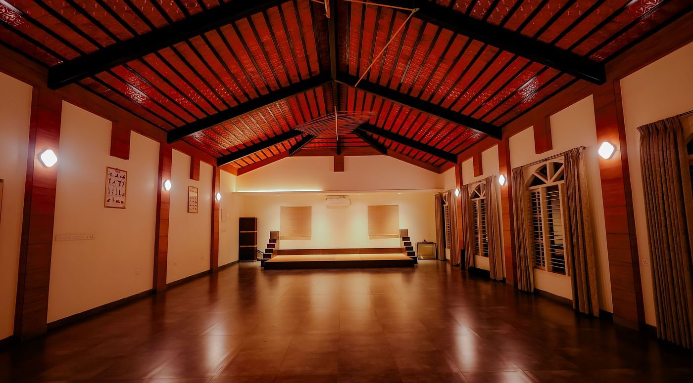 An empty event space or hall with a high ceiling and wooden floor at Nirantara Resort & Spa.
