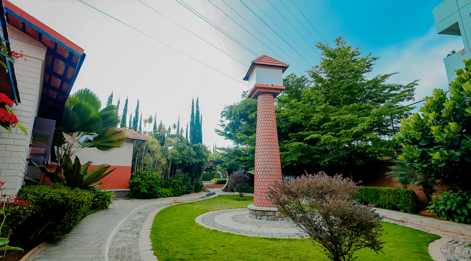 The grounds of Nirantara Resort & Spa with a clock tower, landscaped gardens, and pathways.