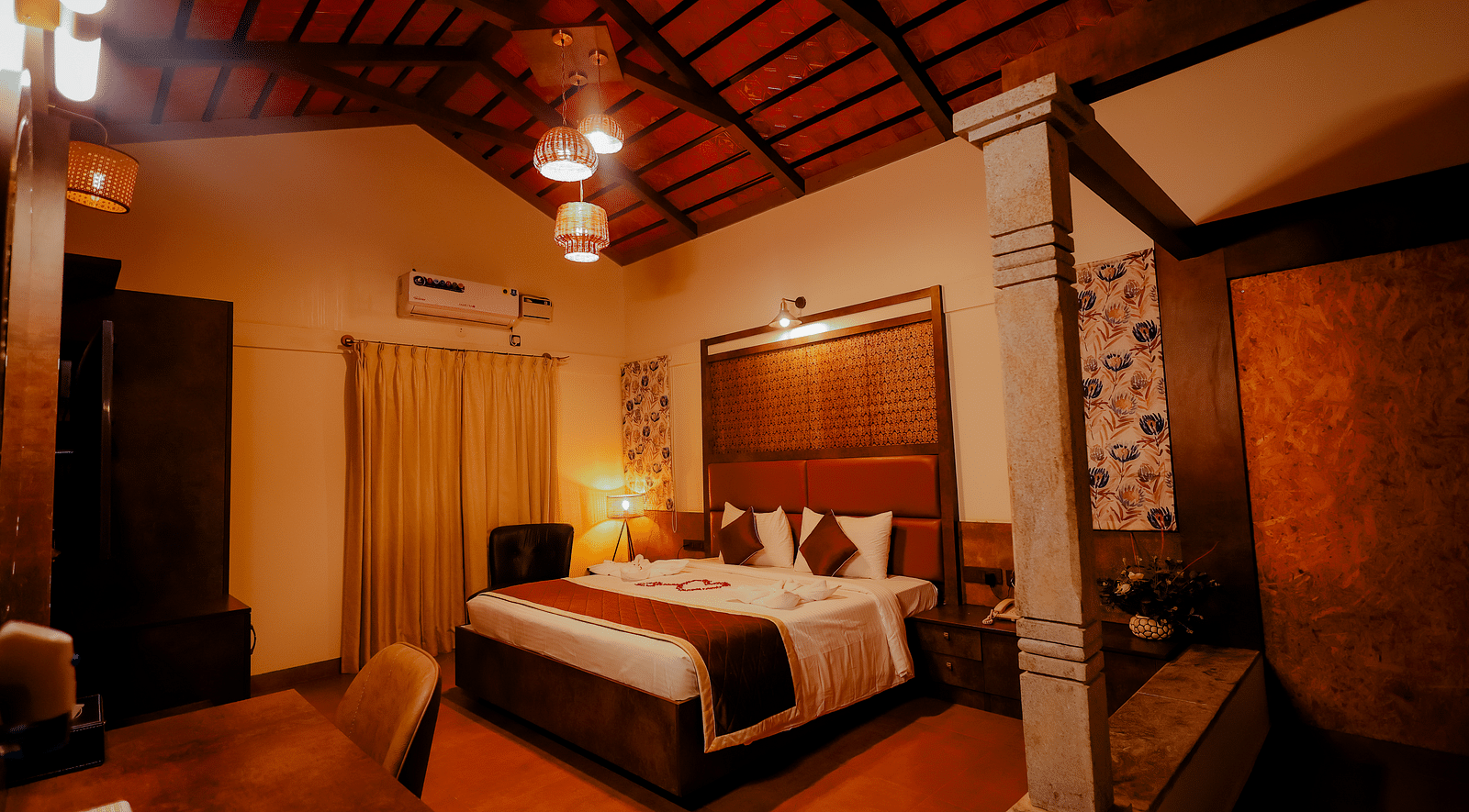 A room with a pitched ceiling and a comfortable bed at Nirantara Resort & Spa.