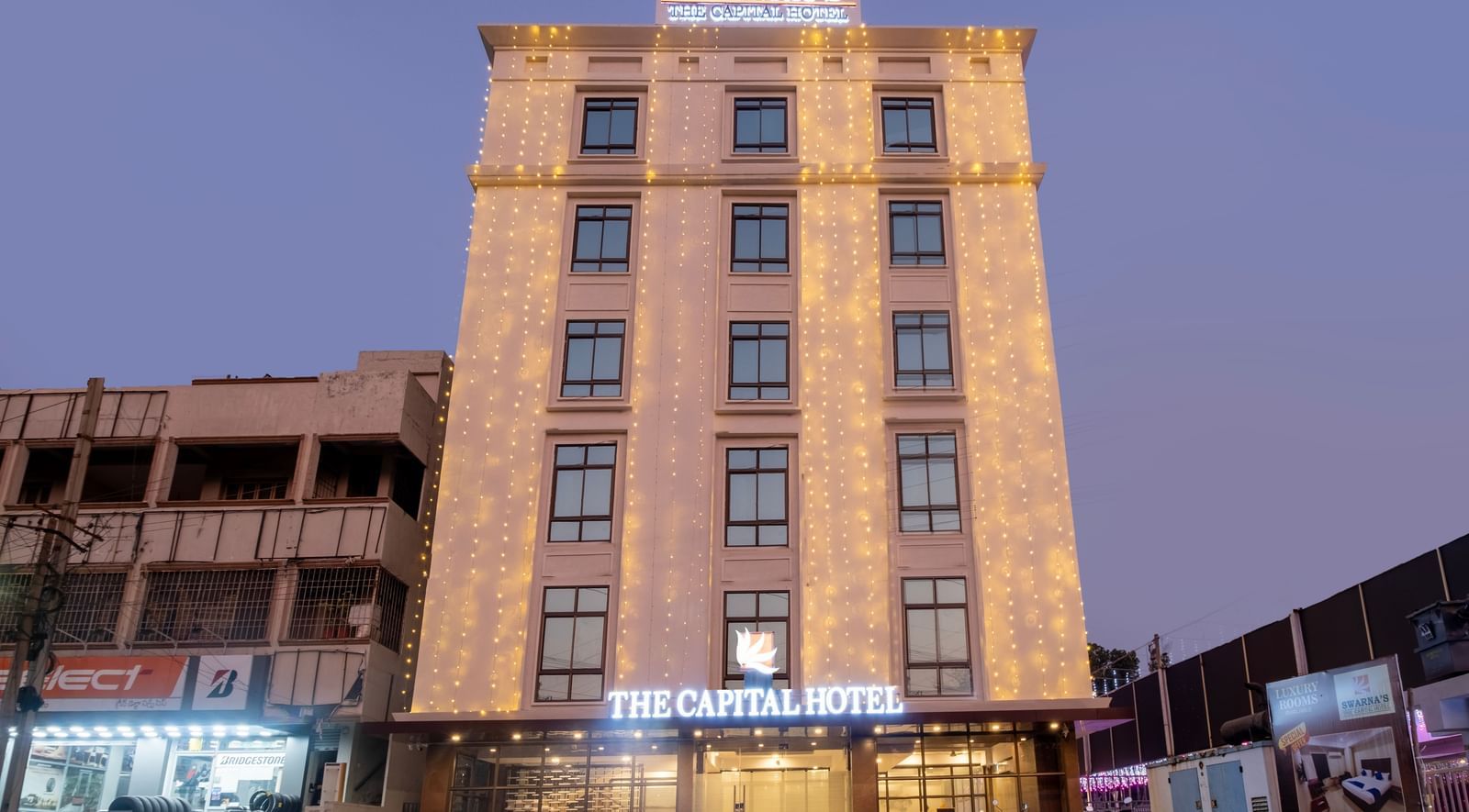 Night view of Swarna's The Capital with its illuminated facade standing tall in the city centre.