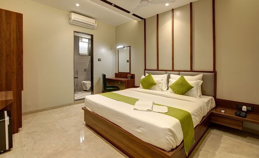 alt-text A double bed with an ac wall mounted next to it inside Classic AC Room - Fortune House, Magarpatta