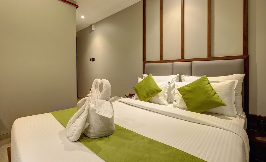 alt-text A double bed with dove towels on top of it inside Classic AC Room - Fortune House, Magarpatta