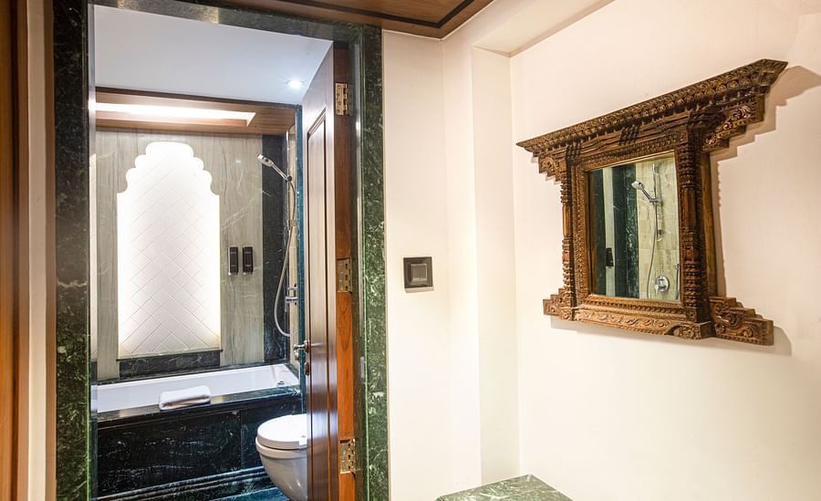 A Rajasthani-themed bathroom adorned with marble and wooden furnishings, reflecting traditional design elements and a warm atmosphere.