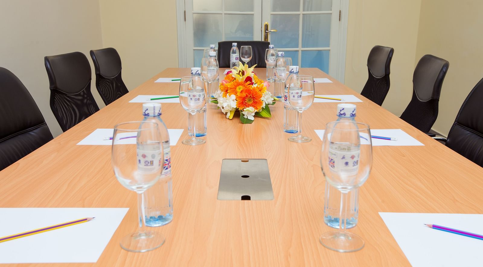 A meeting room with a long table, chairs, and glasses | Conference Hall | Central Mansions, Phnom Penh