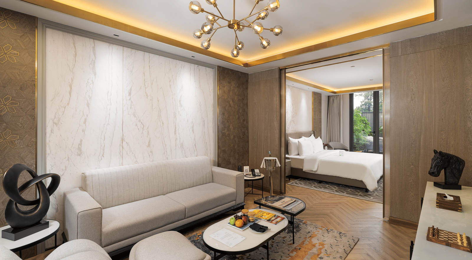 Nirvana Suite living area with a stylish sofa, a chic coffee table, and an open view into the spacious bedroom - Nirvana Luxury Hotel, Ludhiana