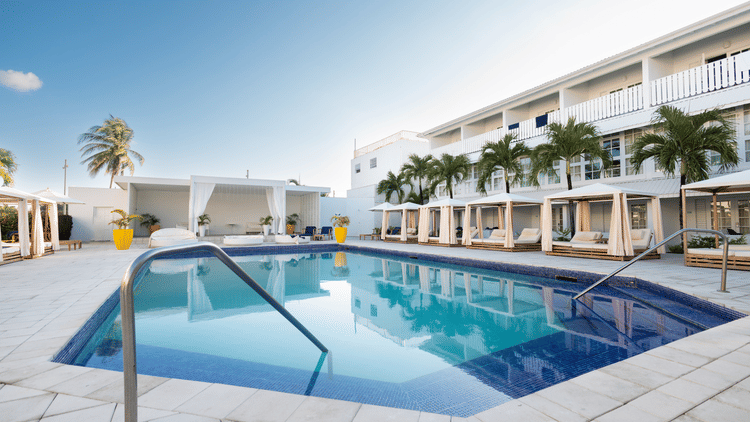 A side angle view of the pool with The Soco House's facade and the lounge space at the backdrop.