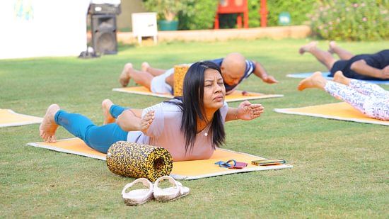 Participants performing yoga poses with focused expressions during a wellness session.