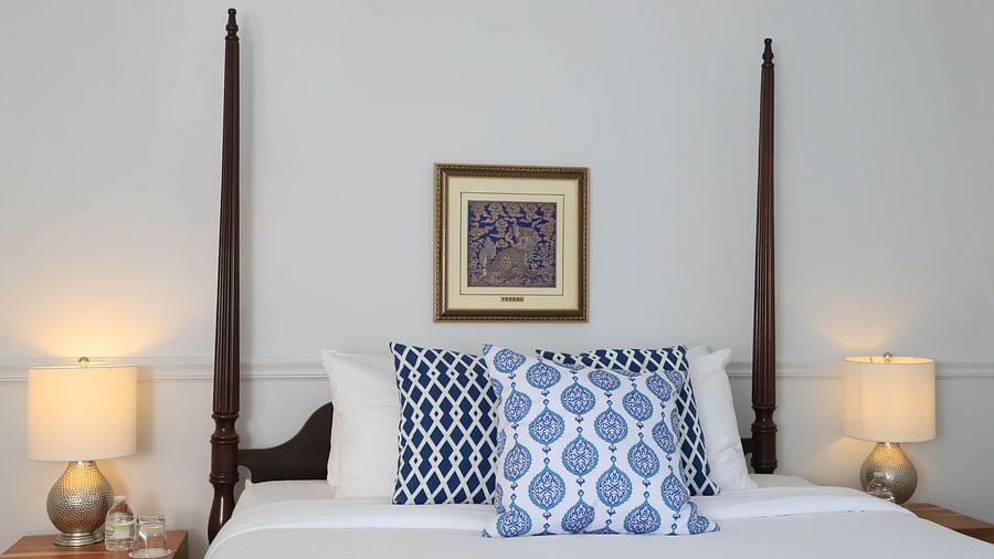 Queen bed with blue accent pillows and framed artwork at Hartstone Inn.