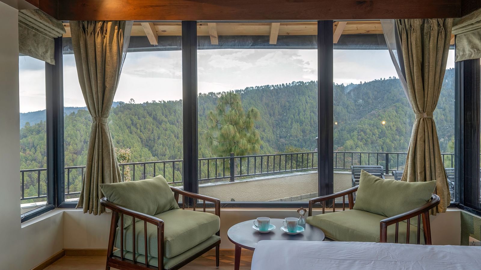 Spacious room with a seating area featuring armchairs and a view through large windows at The Chamomile Estate.