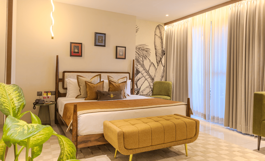 A king size bed with warm linen, large botanical mural in the Suite at Hotel Bawa, Udaipur