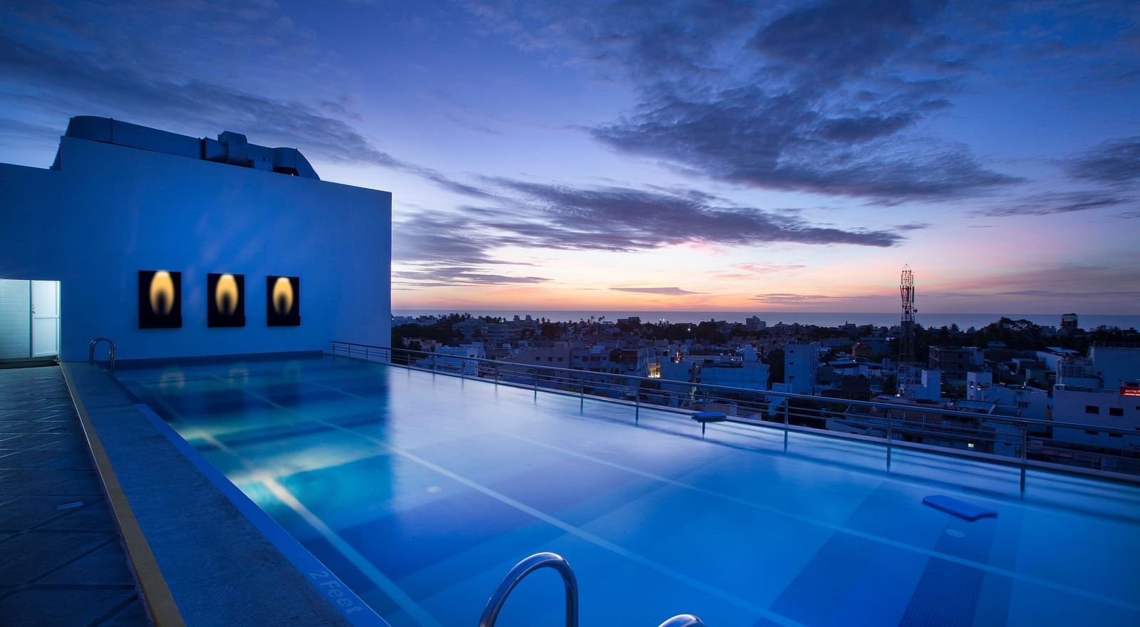 view of a swimming pool at sunset at Hotel Atithi - TGI Grand, Pondicherry