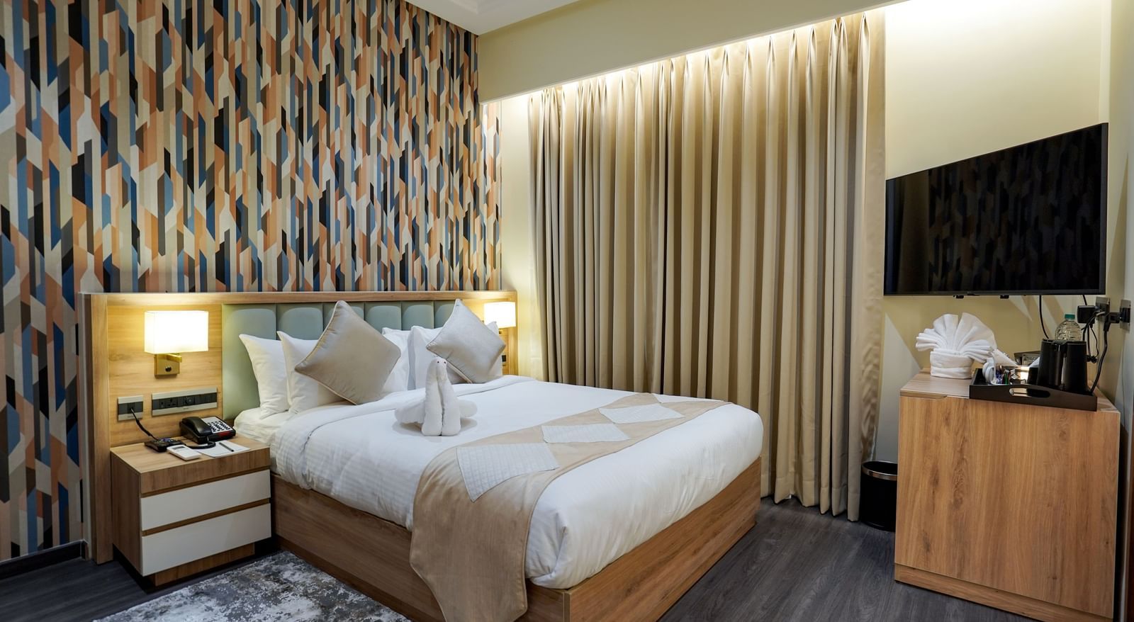 Full view of the Deluxe room featuring a double bed along with a beige coloured bed runner spread over it at M2 Square by Monday Premium.