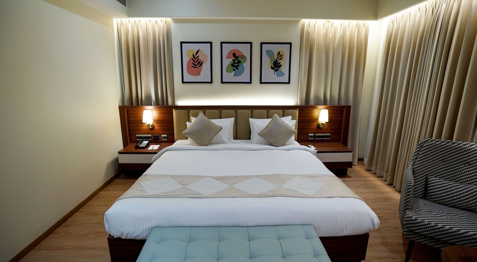 Front view of an well-furnished Superior King Bed Room featuring a king size bed with 2 bed side tables placed on either side of it M2 Square by Monday Premium.