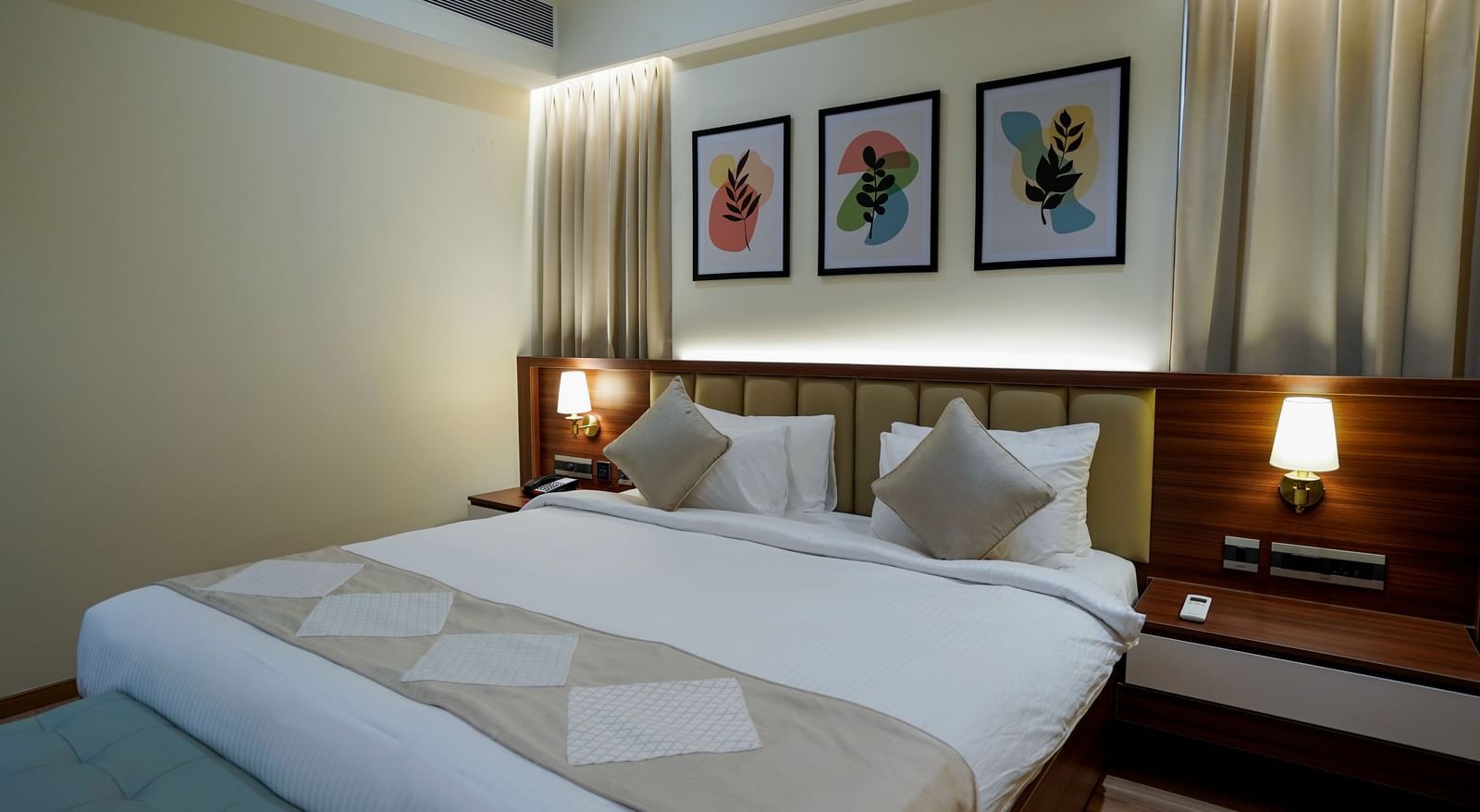 Corner view shot of the king size bed at the Superior King Bed Room along with a beige coloured bed runner kept over it at M2 Square by Monday Premium.