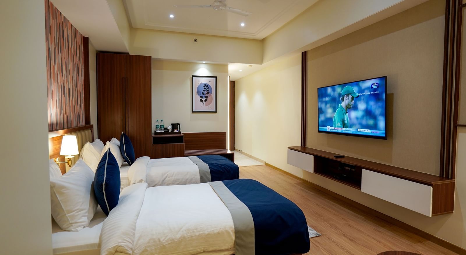 Side view of the Superior Twin Bed Room featuring a wall-mounted television placed opposite to the twin beds at M2 Square by Monday Premium.