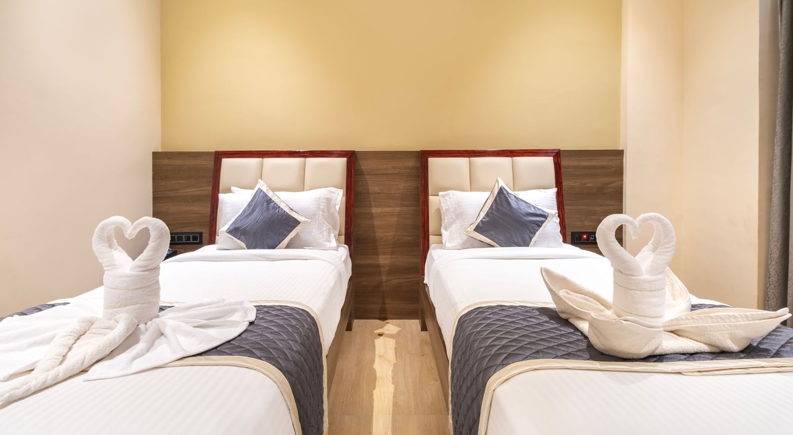 Guest twin room at Monday Hotels Amalapuram Heights with swan towel decor.