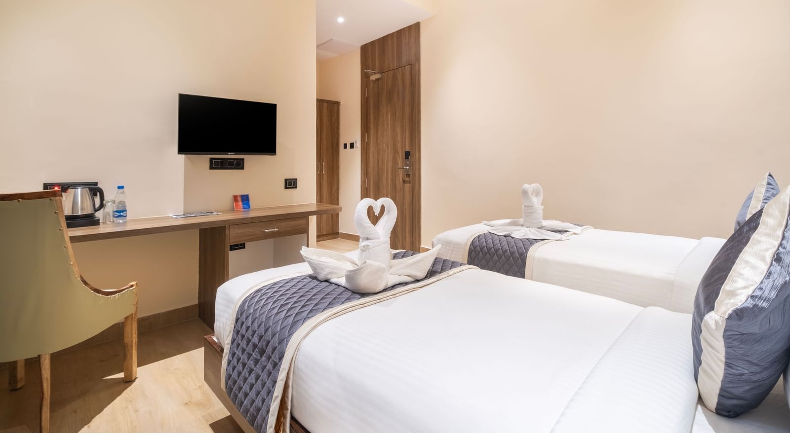 Twin bed room at Monday Hotels Amalapuram Heights with modern amenities.