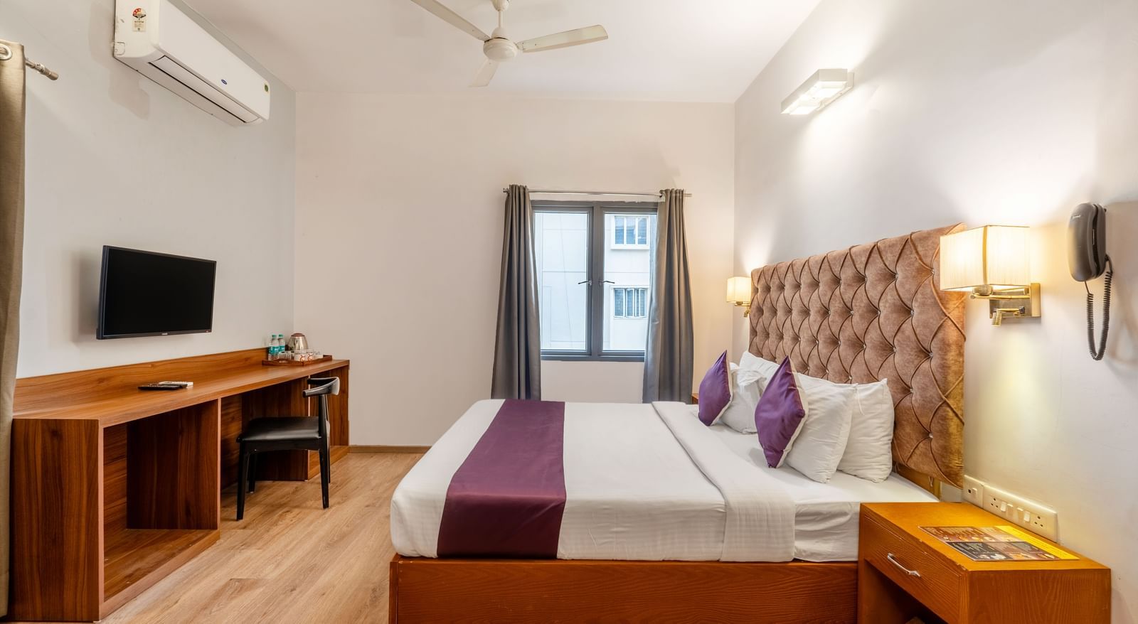 A hotel room with a bed, wall mounted tv, and air conditioning – Monday Hotels HITEC City, Hyderabad