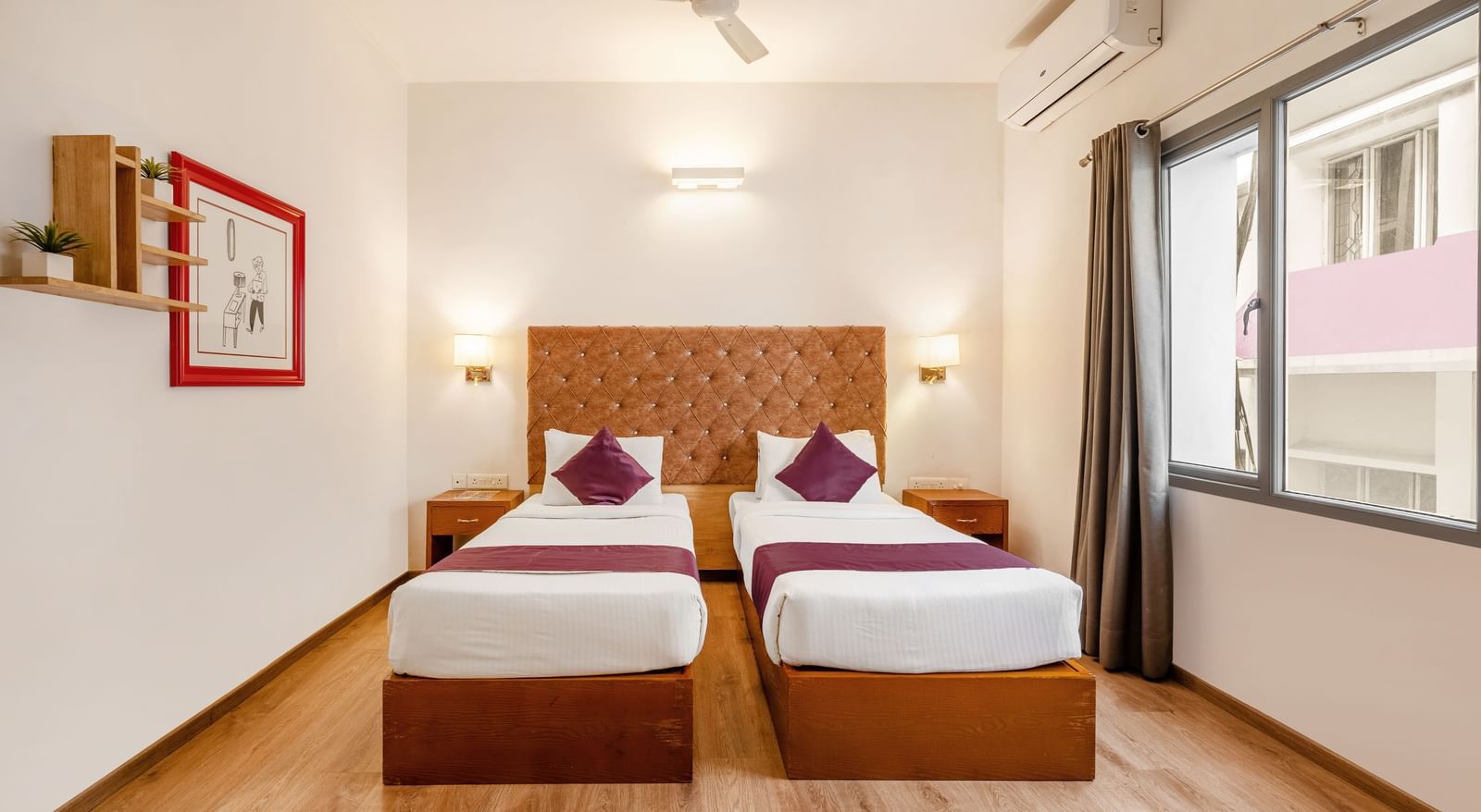 A hotel room with 2 single beds. a ceiling fan and a large window with the curtains opened - Monday Hotels HITEC City, Hyderabad