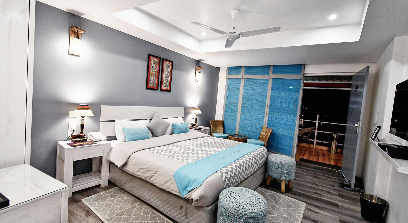 corner view image of the premium room featuring a comfortable double bed with two cushioned stools - The Tattva Boutique Resort