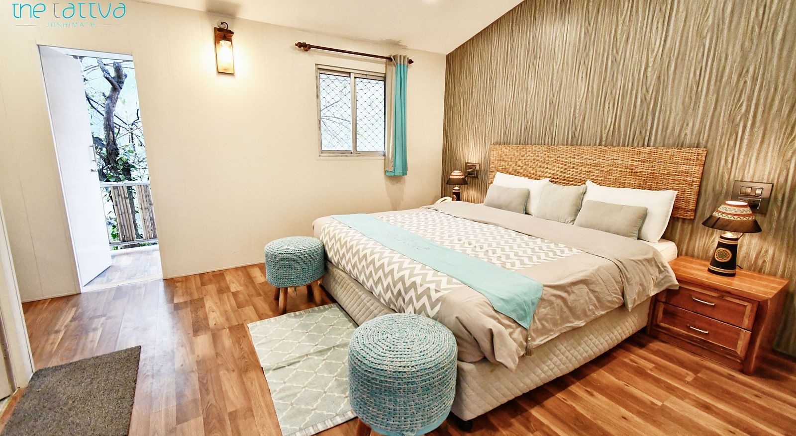full view image of the deluxe room with a plush double bed with warm lighting in the room - The Tattva Boutique Resort