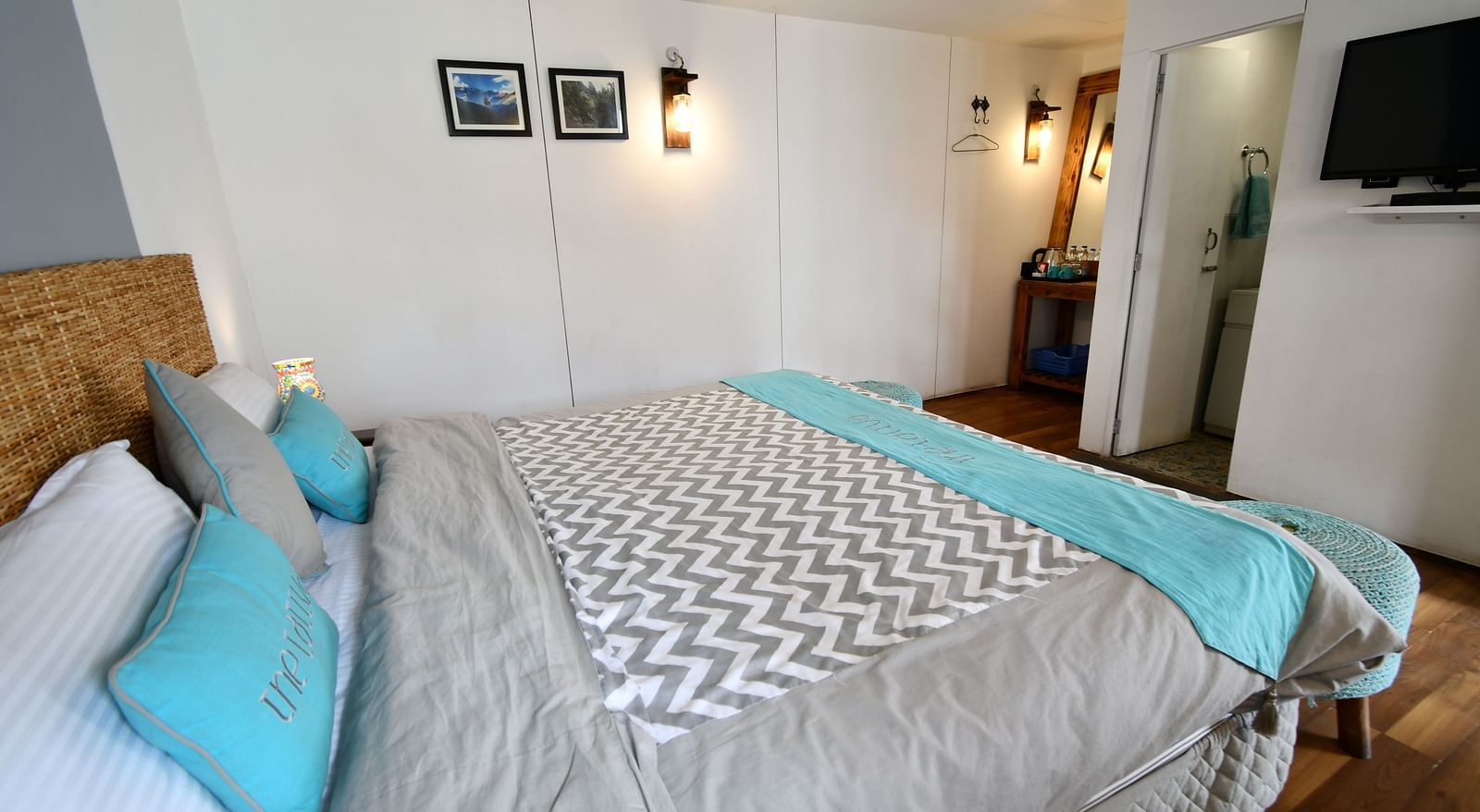 close up image of the double bed in the deluxe room with a soft comforter spread over it - The Tattva Boutique Resort