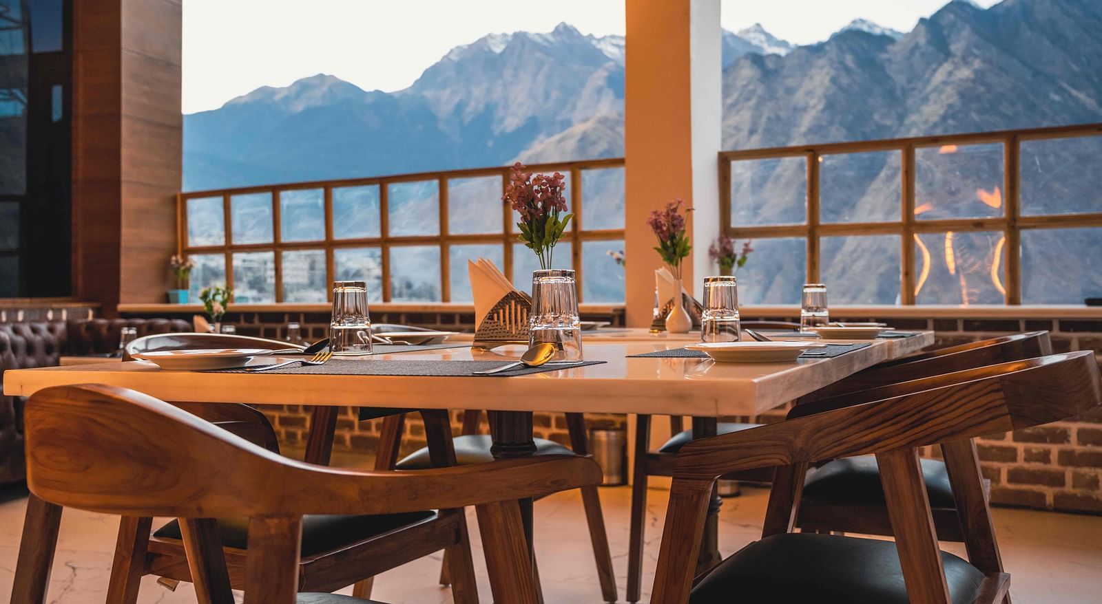 image of the indoor dining area of the alpenrose restaurant featuring a table over looking the beautiful mountain views - the tattva boutique resort