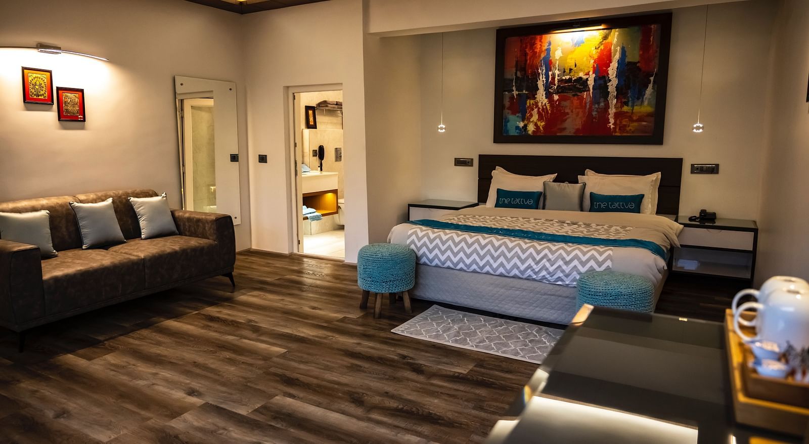front view image of the bedroom at the pent house with a double bed and sofa in the corner of the room - The Tattva Boutique Resort