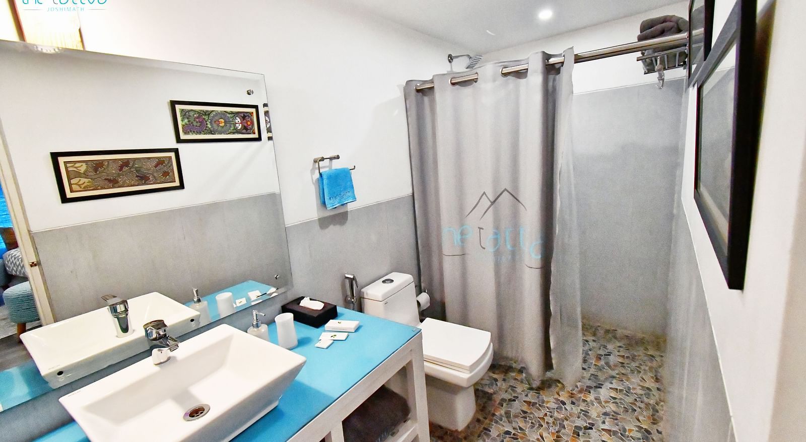 top angle image of the bathroom of the premium room featuring a shower cubical and a wash basin - The Tattva Boutique Resort