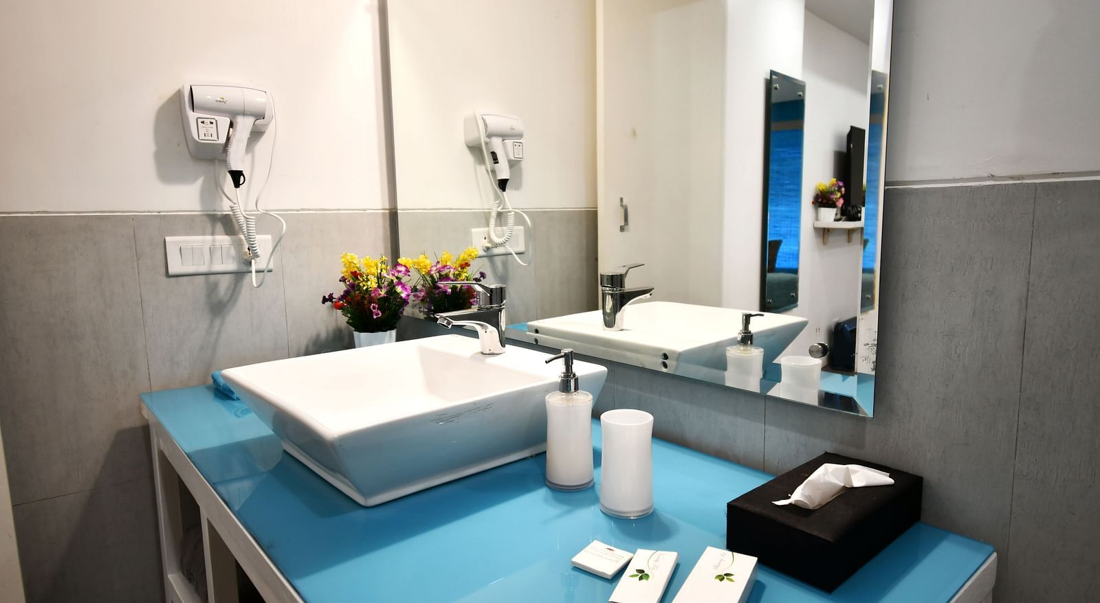 image featuring a neatly kept wash basin surrounded with premium toiletries in the premium room - The Tattva Boutique Resort