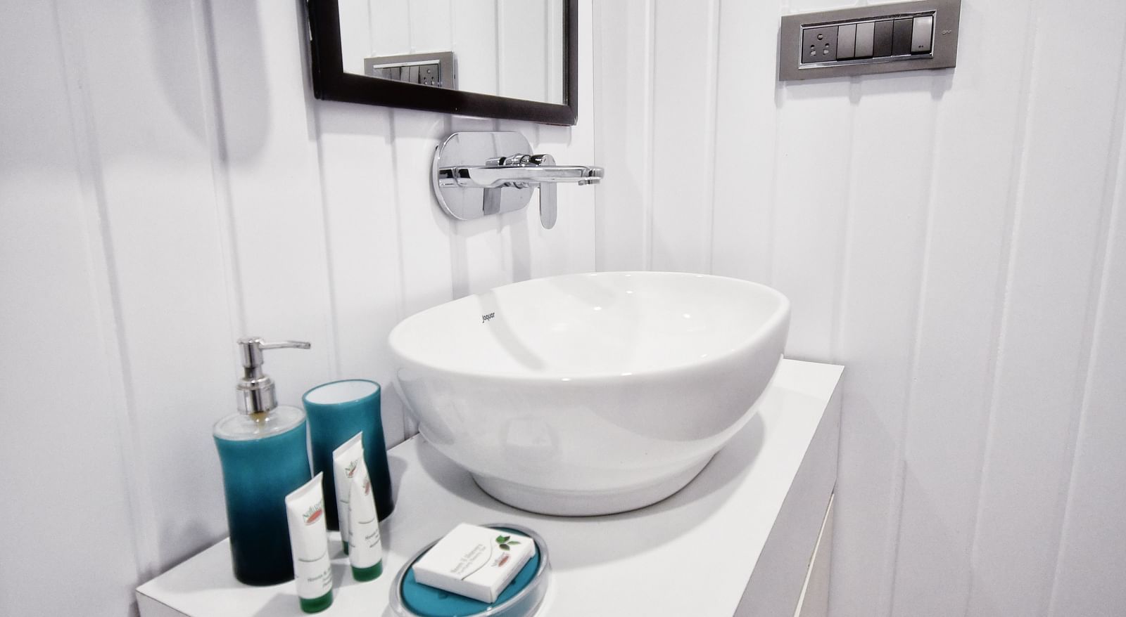 image of a wash basin in the standard room with premium toiletries kept besides it - The Tattva Boutique Resort
