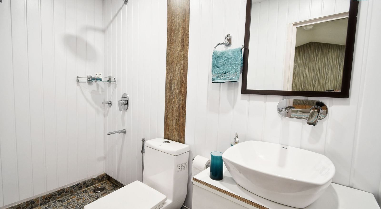 image of the bathroom of the standard room featuring a small wash area along with a commode - The Tattva Boutique Resort
