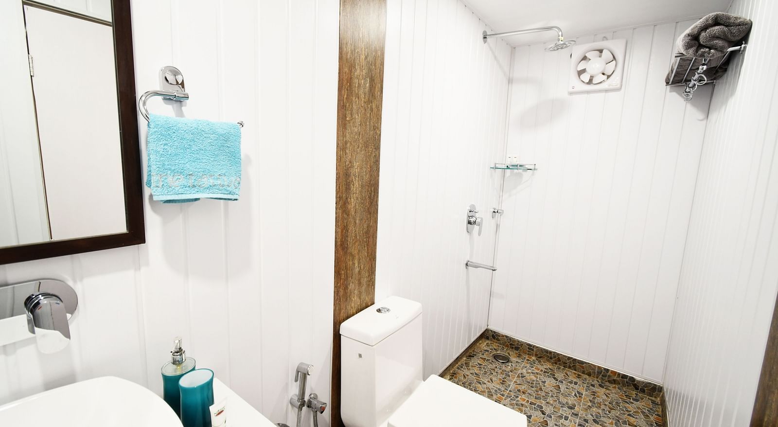 full view image of a small bathroom with white tiles in the standard room - The Tattva Boutique Resort